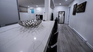 Un espace repas moderne avec une table en marbre, des chaises noires et un élément décoratif central.