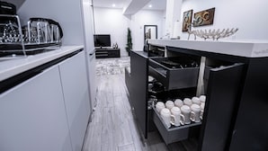Une cuisine moderne avec des armoires blanches, un comptoir noir et un four encastré.