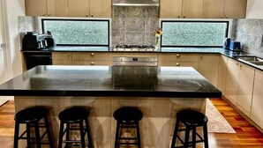 Una cocina moderna con una isla grande, armarios de madera y un salpicadero con diseño.