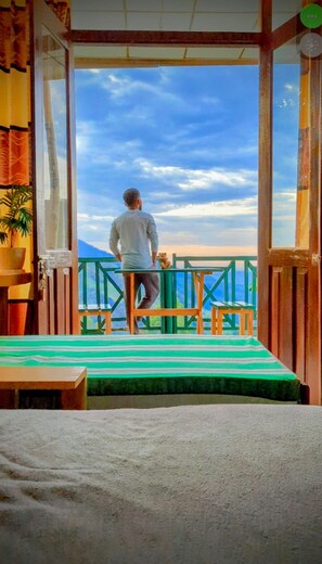 A man standing on a balcony with a view of the sky and mountains. - Misty Cabins Ella (Ella)