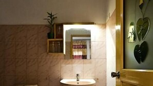 A small bathroom with a toilet, sink, and a mirror. - Misty Cabins Ella (Ella)