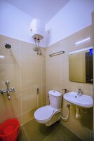 Une salle de bain avec des toilettes, un lavabo et une douche.