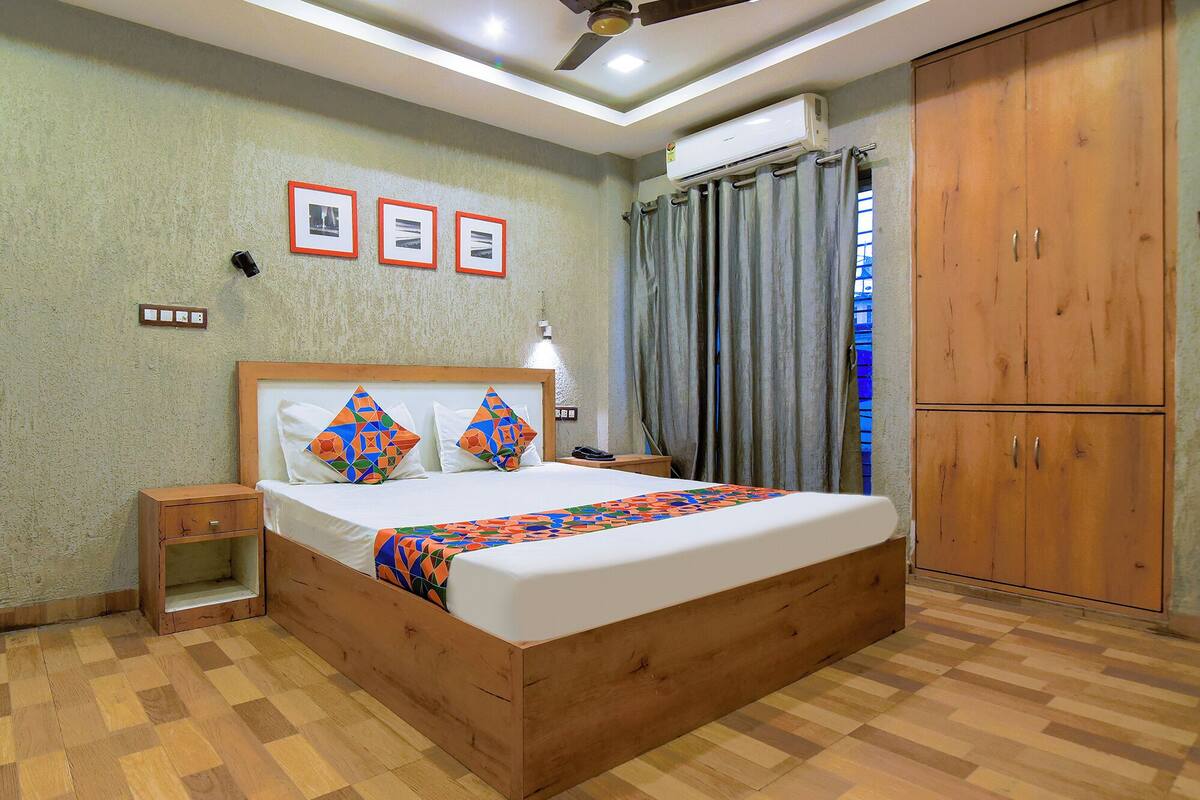 A bedroom with a wooden bed, a nightstand, a wardrobe, and a ceiling fan.