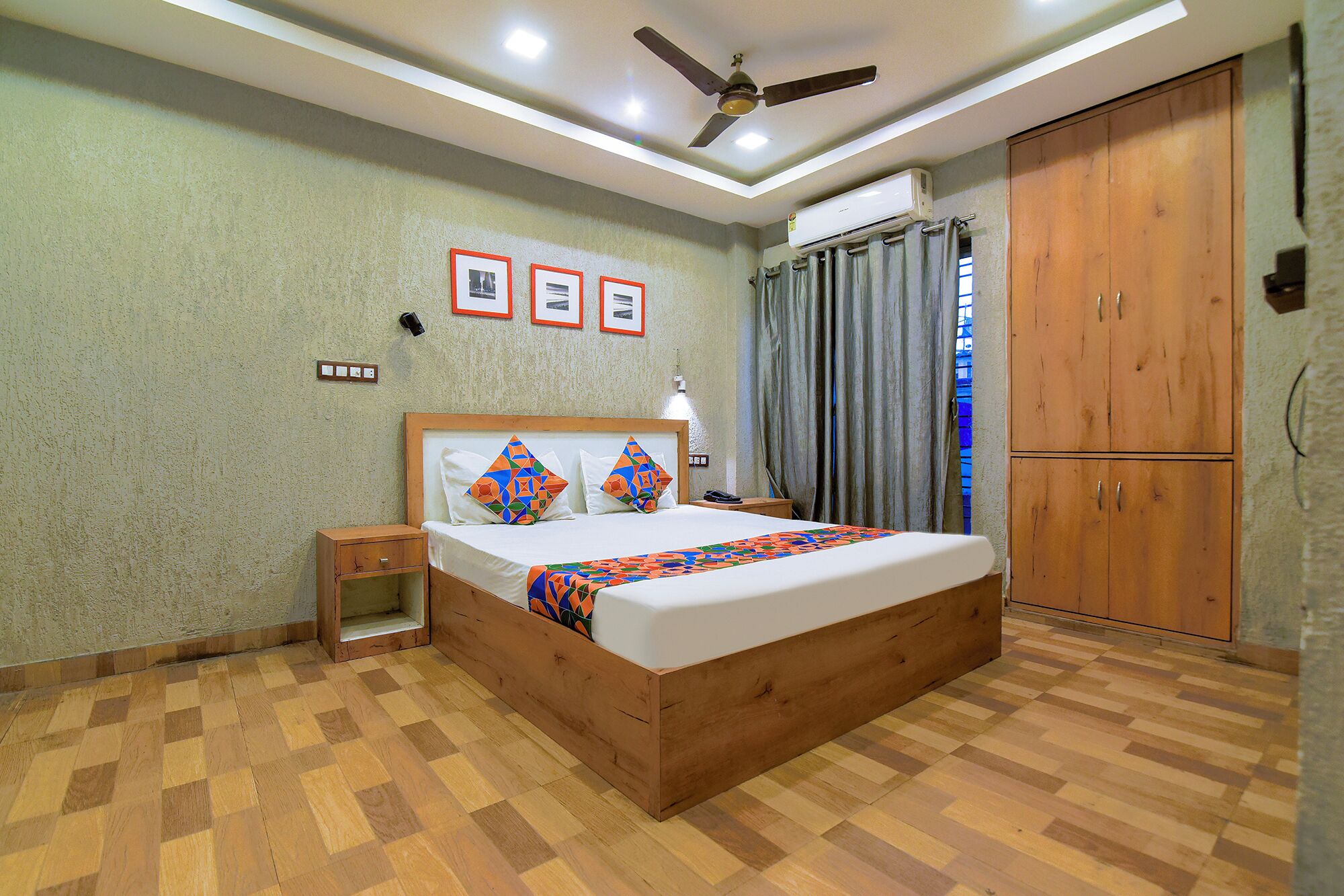 A bedroom with a wooden bed, a nightstand, a ceiling fan, and a wardrobe.