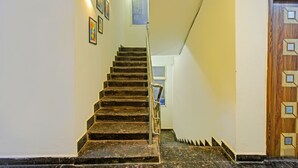 A staircase with a handrail, leading to a door with geometric patterns. - Fabhotel Dolce Vita Grand (Hyderabad)