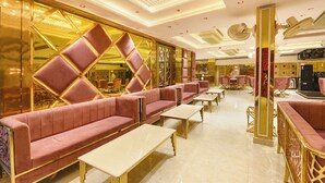 A luxurious hotel lobby with plush seating, a bar area, and a mirrored wall. - FabHotel Prime Shahdara (New Delhi)