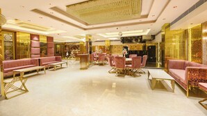 A luxurious hotel lobby with plush seating, a central dining area, and a decorative ceiling. - FabHotel Prime Shahdara (New Delhi)