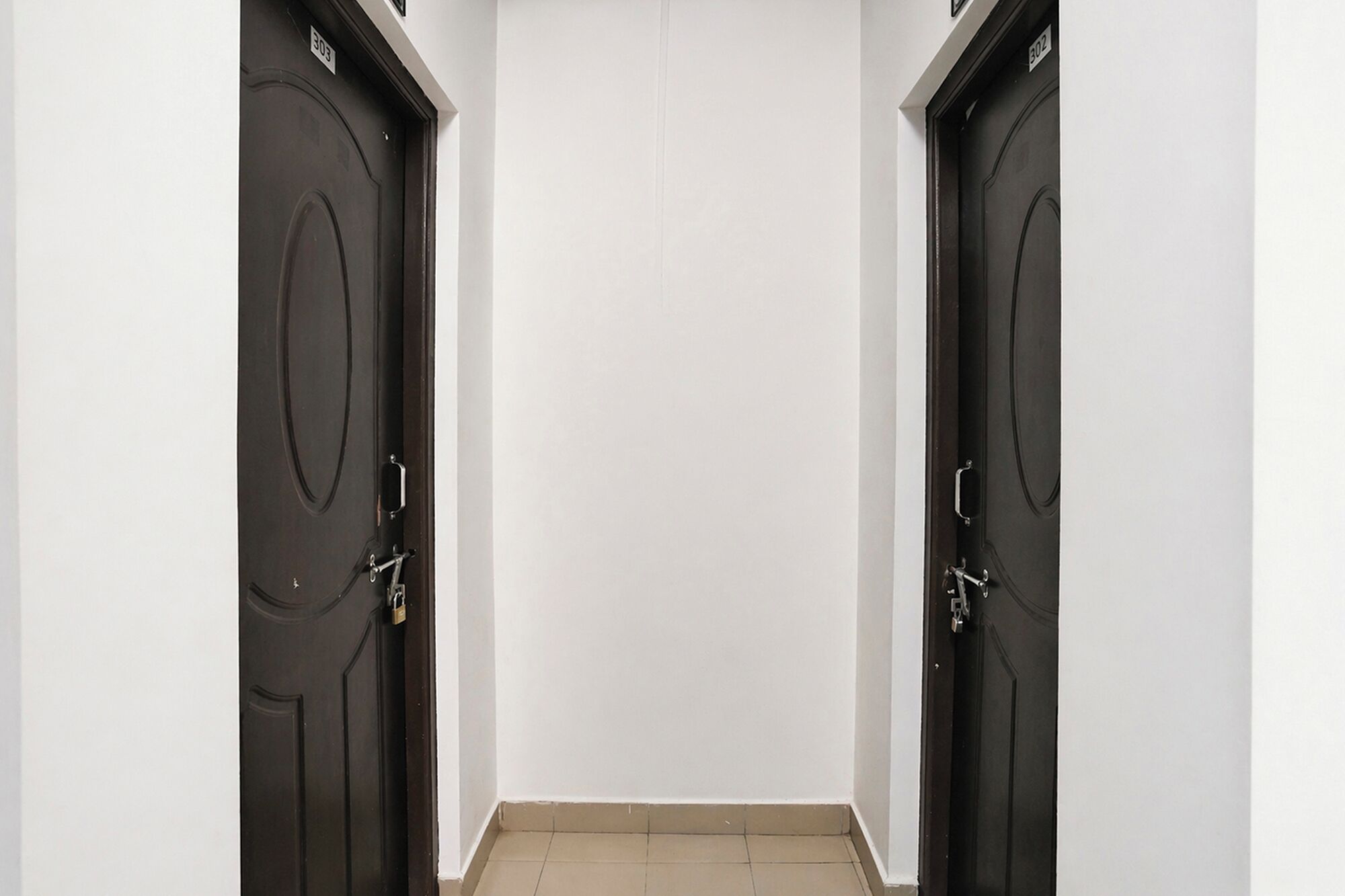 A hallway with two dark wooden doors, each marked with a number.