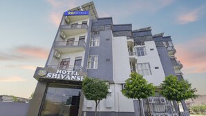 Een hotel met meerdere verdiepingen, met een modern design, balkons en een opvallende entree.