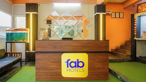 A reception desk with a 'fab hotels' sign, a fish tank, and a staircase. - Fabhotel Galaxy Grand (Panvel)