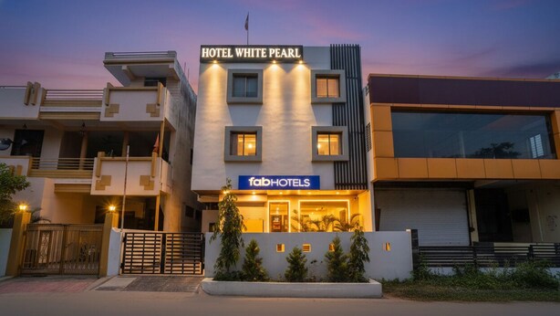 Ein modernes Hotel mit einem gut sichtbaren Schild, auf dem „HOTEL WHITE PEARL“ und darunter „fabHOTELS“ steht.