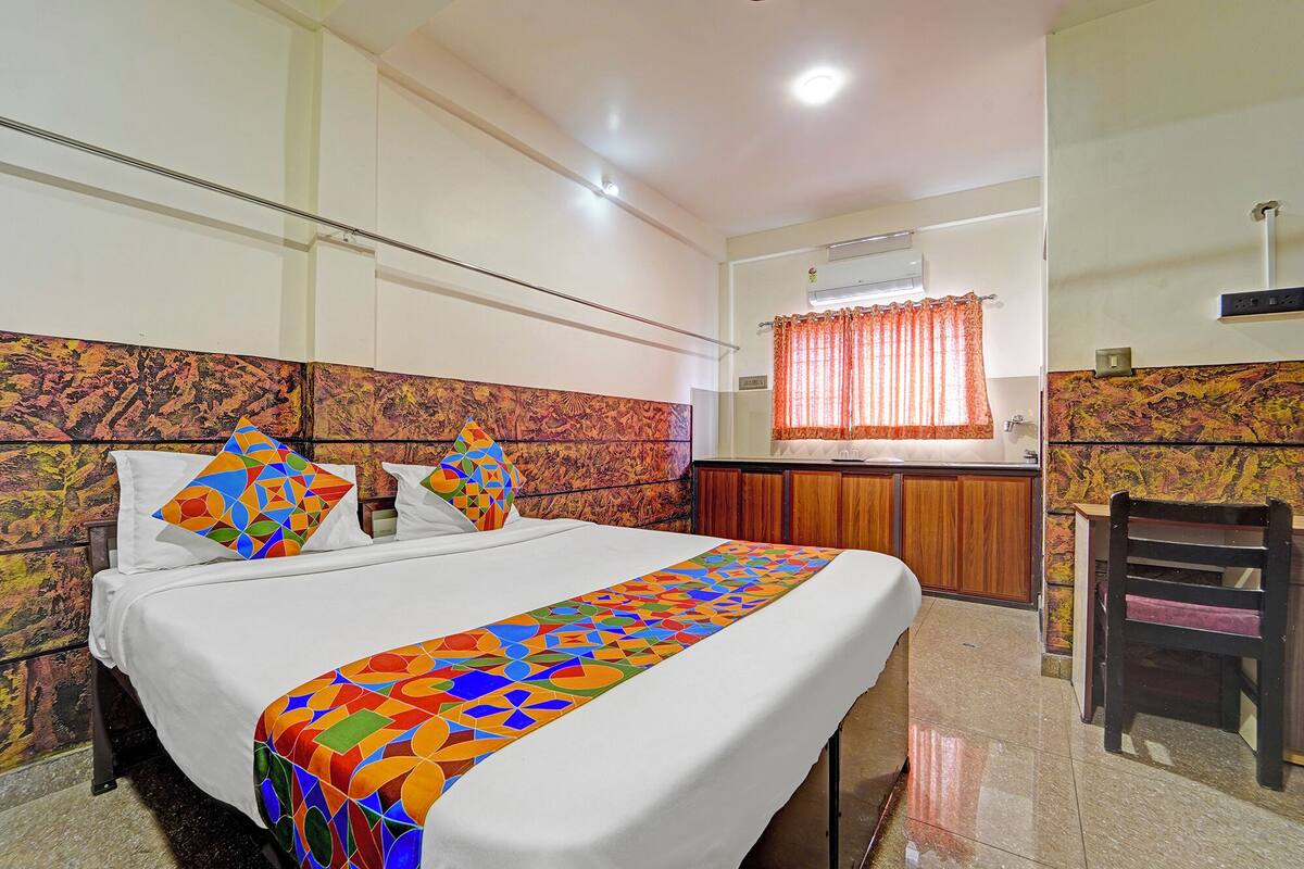 A hotel room with a bed, a desk, and a chair.