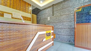 A hotel reception desk with a wooden finish and a sign for 'fab hotels'. - Fabhotel Pk Residency (Ernakulam)