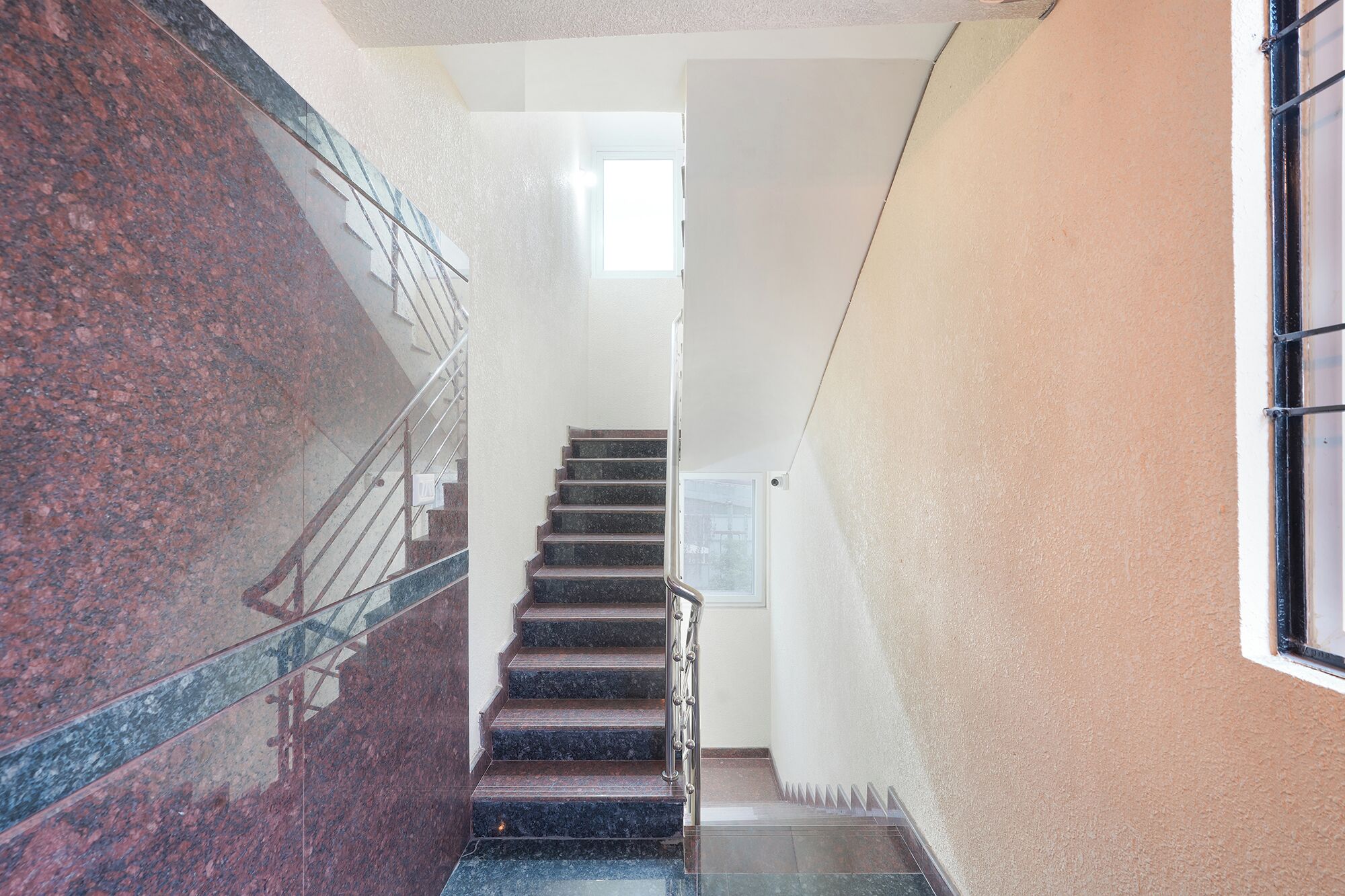 A staircase with a metal railing and a glass door at the top.