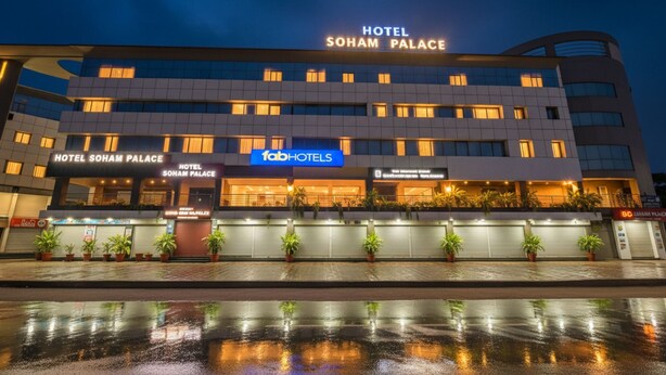 Un hotel de varios pisos con un cartel llamativo que dice "HOTEL SOHAM PALACE".