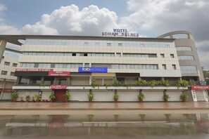 Un hotel de varios pisos con fachada moderna, destacando un cartel con el nombre 'Hotel Soham Palace'.