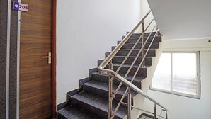 Un escalier avec des rampes en métal, une porte en bois et une fenêtre donnant sur un paysage agréable.