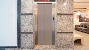An elevator with a sign indicating "6 members only" and an "EXIT" sign above it. - Fabhotel Wild Wings Kothapet (Hyderabad)