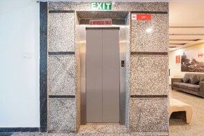 An elevator with a sign indicating "6 members only" and an "EXIT" sign above it. - Fabhotel Wild Wings Kothapet (Hyderabad)