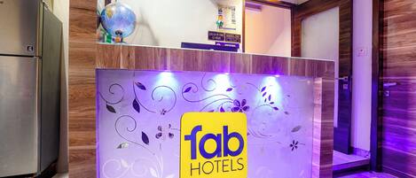 Una recepción con el logotipo de 'fab hotels', un globo terráqueo y un ventilador.