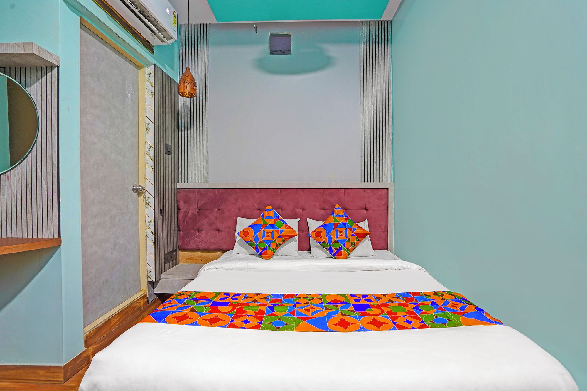 A bedroom with a bed, two pillows, a window, and a door.