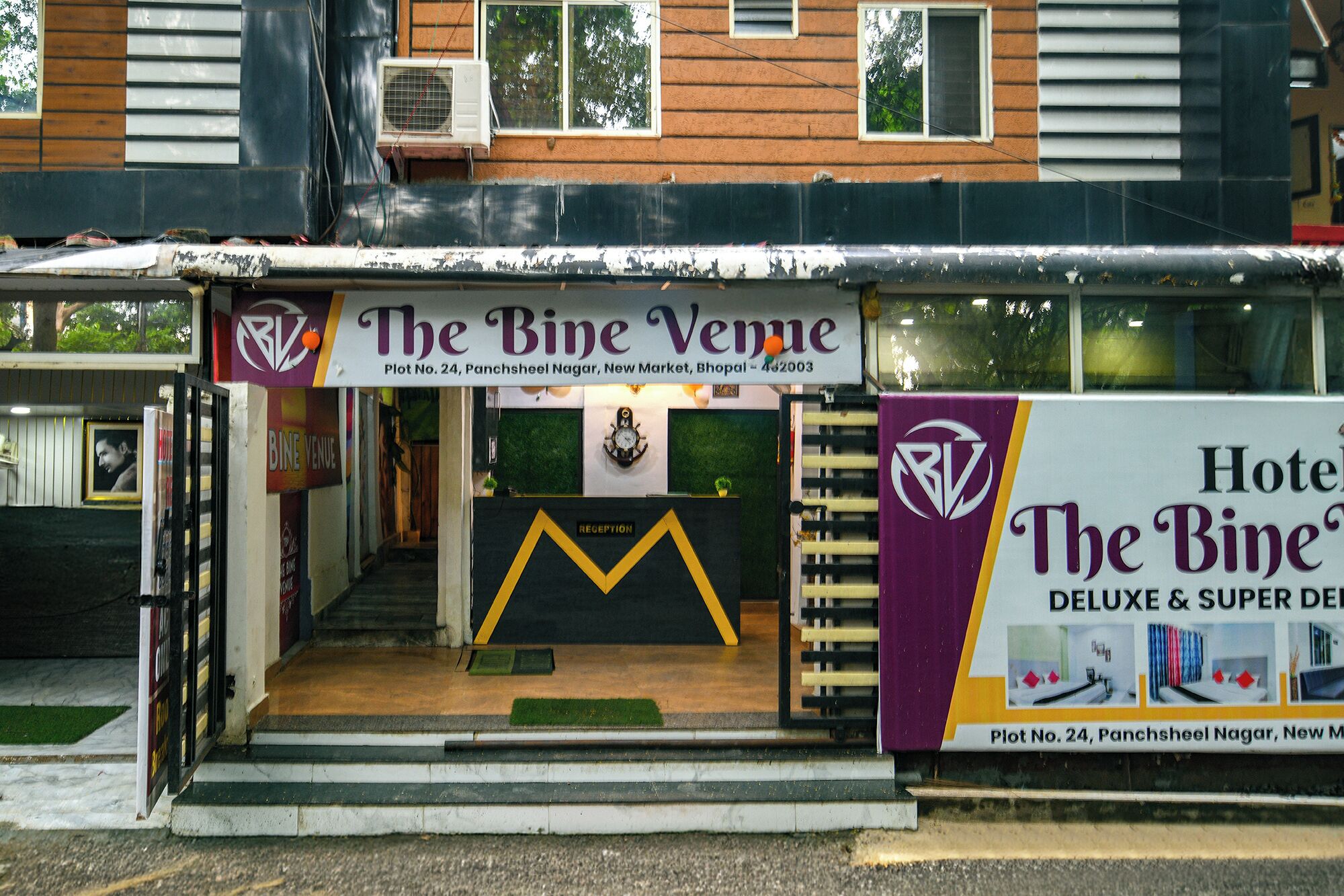 A hotel entrance with a sign for 'The Bine Venue' and a reception desk.