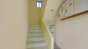 A staircase with white marble steps leading to a landing. - Fabhotel Shree Sai Inn (Paud)