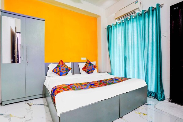 A bedroom with a bed, a wardrobe, a bathroom door, and a curtain. - FabHotel Lotus Prime Stay - Hinjawadi (Paud)