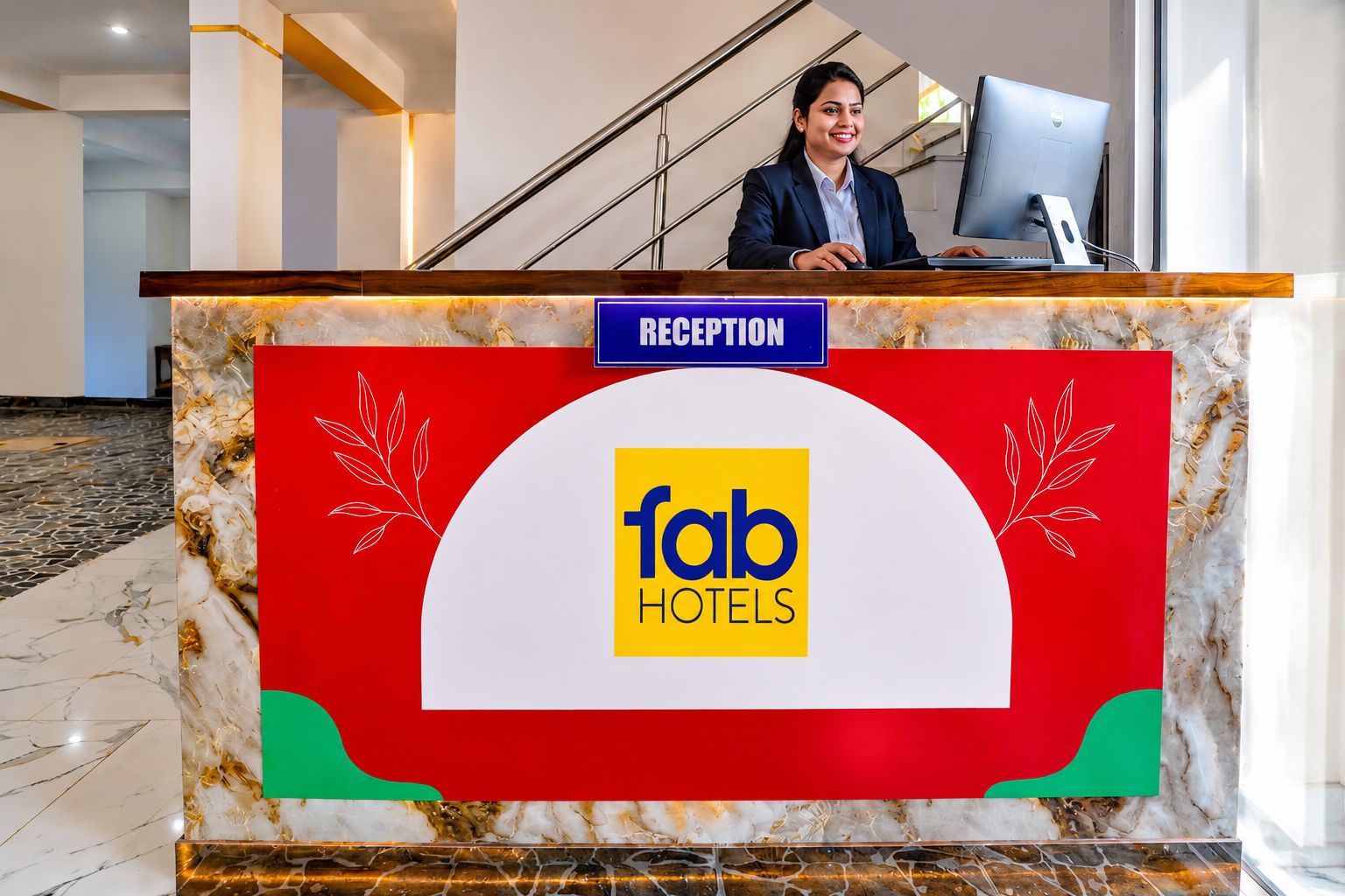 Una mesa de recepción con un letrero que dice 'fab Hotels' y un monitor de computadora.