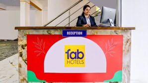 A reception desk with a sign reading 'RECEPTION' and 'fab HOTELS' logo. - FabHotel Lotus Prime Stay (Paud)