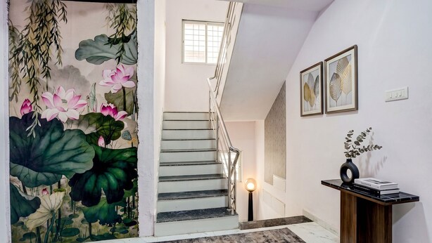 A staircase with a railing, a wall-mounted light, and a framed botanical print. - FabHotel Lotus Prime Stay - Hinjawadi (Paud)