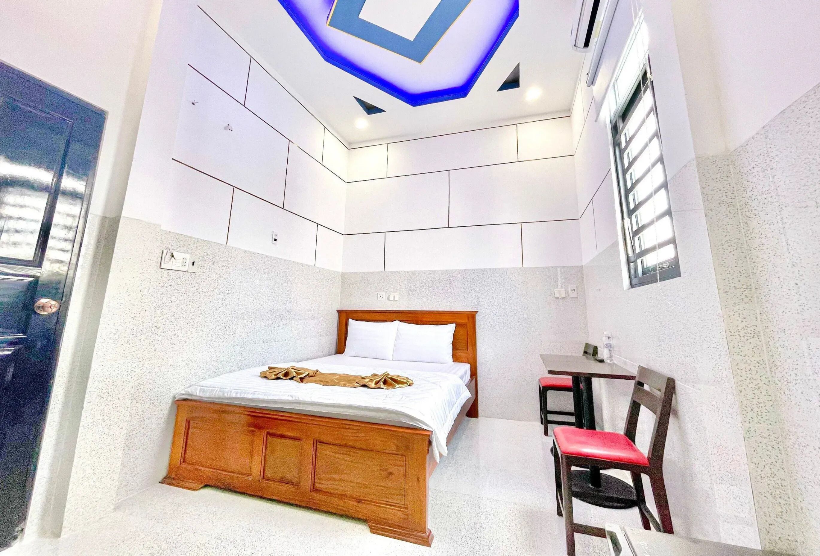 Ein Schlafzimmer mit einem hölzernen Bett, einem Schreibtisch und einem Stuhl.