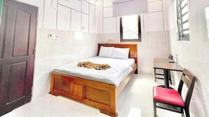 Una habitación de hotel moderna con una cama de madera, un escritorio y una silla.