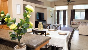 A dining area with a granite countertop, a potted plant, and a table set for four. - Delightful home 5 Bedrooms , 2 Bath and 2 living rooms  (Bakersfield)