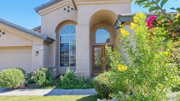 A residential building with a beige facade, two arched windows, and a front door. - Delightful home 5 Bedrooms , 2 Bath and 2 living rooms  (Bakersfield)