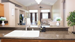 A kitchen with granite countertops, a white sink, and a chandelier. - Delightful home 5 Bedrooms , 2 Bath and 2 living rooms  (Bakersfield)