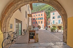 A cobblestone street with a sign for 'Ristorante Il Gallo' and bicycles parked on the side. - Nido dell'Usignolo (Riva del Garda)