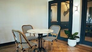 Un comedor con una mesa redonda y cuatro sillas, una planta en maceta y una puerta decorada con un venado.