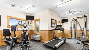 Une salle de sport équipée de tapis de course, de vélos elliptiques et de matériel de musculation.