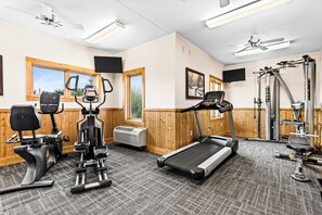 A gym with treadmills, elliptical machines, and weight equipment.