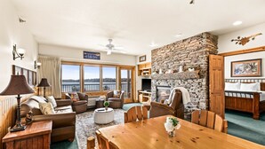 A spacious living area with a fireplace, a dining table, and a view of the outdoors.