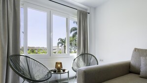 A room with a sofa, two chairs, a small table with a lamp, and a window with curtains. - Sunstay Carlota Flat II Torremolinos (Torremolinos)