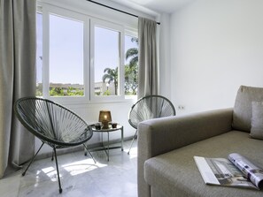 A room with a sofa, two chairs, a small table with a lamp, and a window with curtains. - Sunstay Carlota Flat II Torremolinos (Torremolinos)