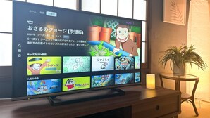 Televisor de pantalla plana sobre un atril de madera mostrando la interfaz de un canal de televisión japonés con diversas opciones de programación.