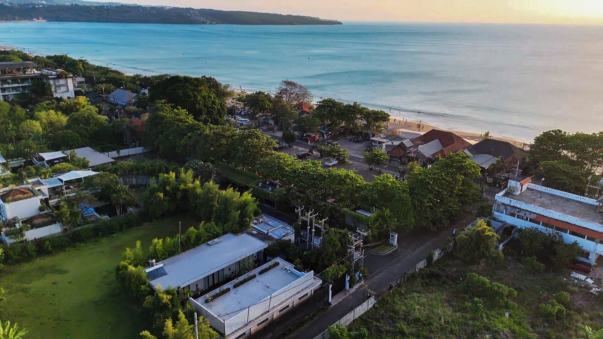 Vista aérea de un pueblo costero con edificios, carreteras y una playa.
