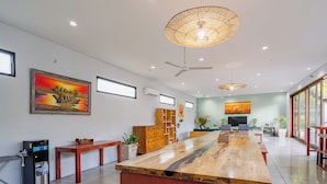 A spacious room with a long wooden table, ceiling fans, and artwork on the walls. - Jimbaran Beach Bliss Villa Bali (Kedonganan)