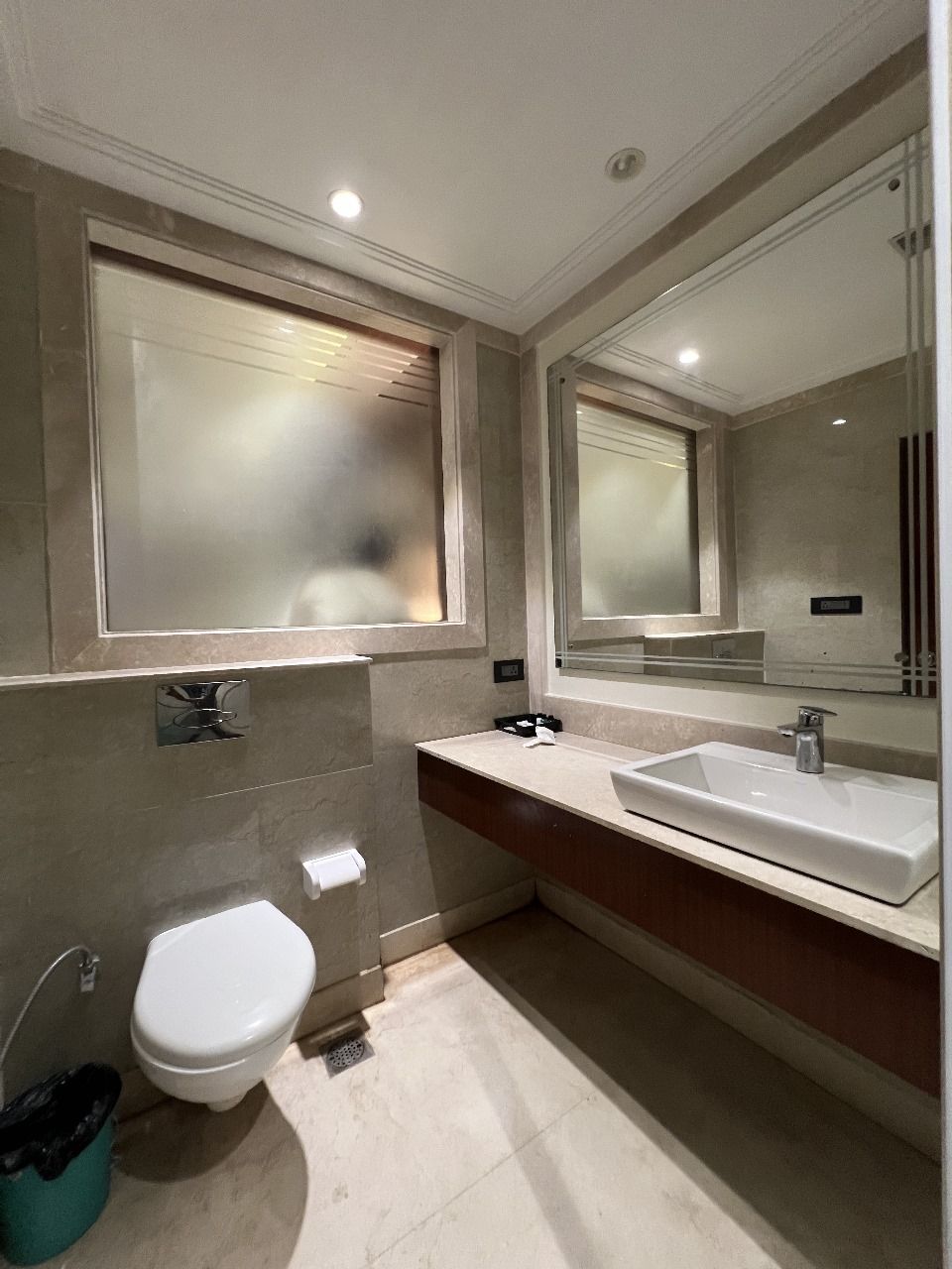 Un bagno moderno con il water, un lavandino e un grande specchio.