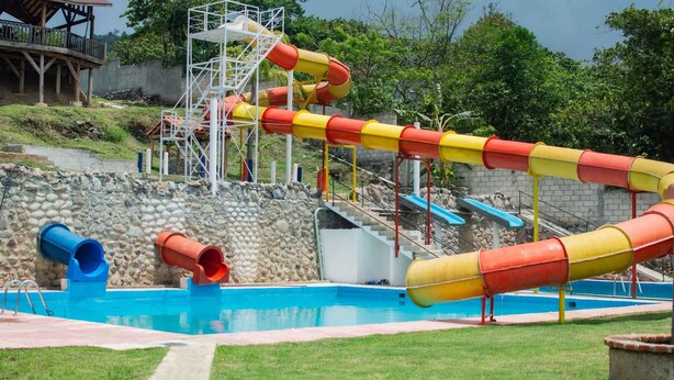 Un parc aquatique doté d’une piscine, de toboggans et d’une structure en bois.