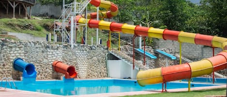 Parque acuático con piscina, toboganes y una estructura de madera.