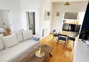 Una sala de estar moderna con un sofá, una mesa de centro y un comedor con sillas.